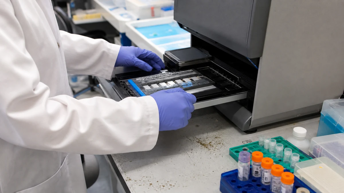 Técnico procesando muestras en un secuenciador NGS de laboratorio